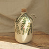 Ceramic bottle with floral design and cork stopper on a wooden surface